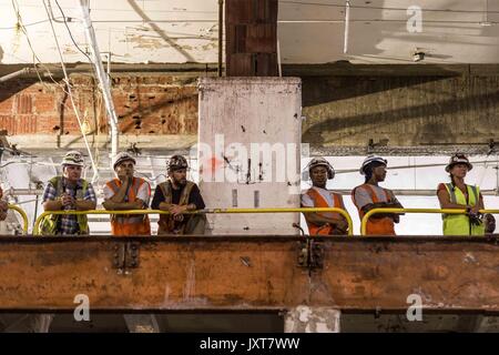 New York City, New York, USA. Août 17, 2017. Les travailleurs de la construction de la nouvelle gare d'observer l'événement. Gouverneur Cuomo et Maura Moynihan, la fille de l'ancien sénateur de New York Daniel Patrick Moynihan, consacrer le nouveau train Moynihan Hall. La nouvelle salle est sous le service postal bâtiment derrière New York Penn Station est la 8e Avenue côté et est un élément crucial du développement conçu pour aider à soutenir le développement de la ville, loin du côté ouest. Credit : Sachelle Babbar/ZUMA/Alamy Fil Live News Banque D'Images