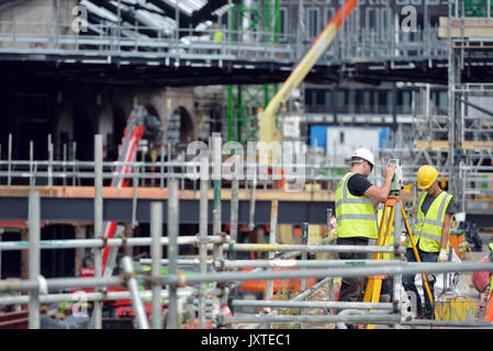 Travailleurs et des arpenteurs en gouttes de charbon, de Cour d'un grand chantier de construction dans le centre de Londres Banque D'Images