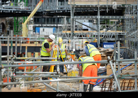 Travailleurs et des arpenteurs en gouttes de charbon, de Cour d'un grand chantier de construction dans le centre de Londres Banque D'Images