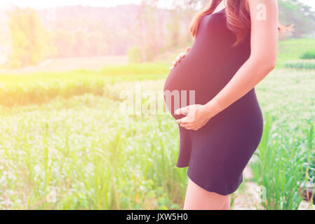 Une femme enceinte à ferme, montrer ventre, bébé bientôt sur le monde Banque D'Images