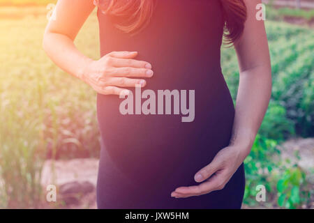 Une femme enceinte à ferme, montrer ventre, bébé bientôt sur le monde Banque D'Images