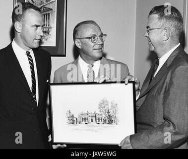 Homewood house, Milton stover Eisenhower, photo d'une photo de l'établissement Homewood house étant détenu par Milton Eisenhower, avec deux hommes debout de chaque côté de lui, 1962. Banque D'Images