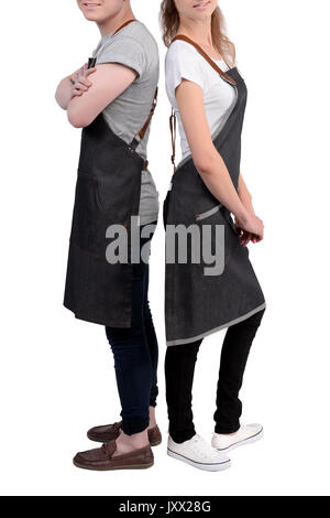 Jeunes chefs ou maîtres d'homme et de la femme pose, portant des tabliers isolé sur fond blanc. Café café barista uniforme. Banque D'Images