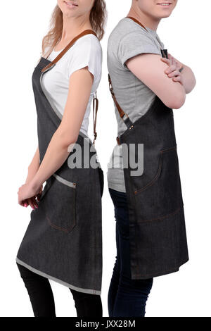 Jeunes chefs ou maîtres d'homme et de la femme pose, portant des tabliers isolé sur fond blanc. Café café barista uniforme. Banque D'Images