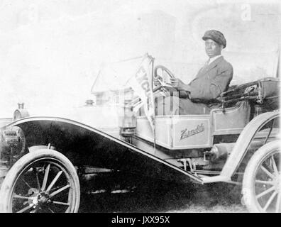 Trois quarts de tir d'un homme américain africain conduisant un Hupmobile, portant un costume et un chapeau, expression faciale neutre, 'First Hupmobile a été construit en 1908', 1908. Banque D'Images