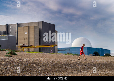 Un jeune garçon marche sur la plage en face de Sizewell de Sizewell B un réacteurs Magnox et réacteurs nucléaires PWR Sizewell, Plage, Suffolk, Angleterre Banque D'Images