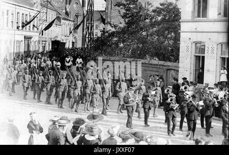 Parade militaire de l'armée avec les hommes marchant dans la rue, chacune portant une arme à feu, un grand nombre de téléspectateurs regarder sur, 1920. Banque D'Images