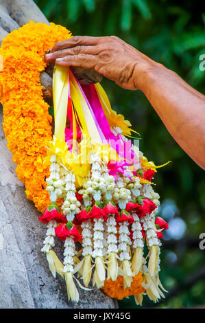 Main sur une bande de Garland à main de Bouddha Statue pour payer le respect. Banque D'Images