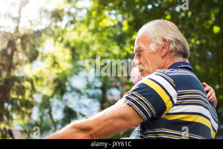 Senior man riding bicycle avec sa petite-fille dans ses mains Banque D'Images