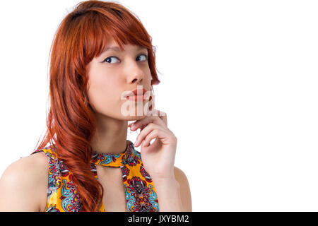 Femme à l'air étrangement sur le côté. Redhead girl wearing yellow et robe colorée. Motif floral. Mode et Style. L'été et tropicales clim Banque D'Images