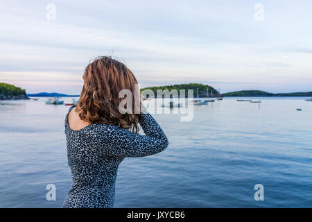 Portrait de dos de jeune femme cheveux toucher sur le bord de quai à Bar Harbor, Maine au coucher du soleil Banque D'Images