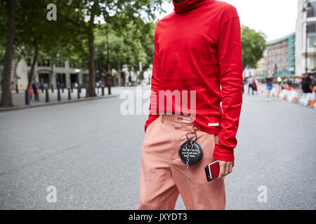 Mid section of man in red polo neck top et pantalons roses Banque D'Images