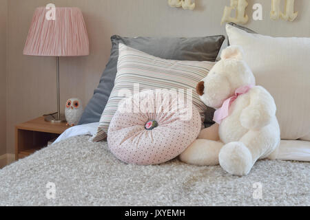 Chambre d'enfant moderne à la poupée et les oreillers sur le lit Banque D'Images