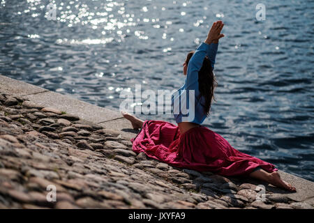 Mettre en place sportive woman faisant l'asana Virabhadrasana 2 guerrier pose posture dans la nature. Banque D'Images