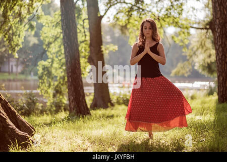 Séduisant jeune femelle est la pratique du yoga et de faire l'asana Vrikshasana le matin. Banque D'Images