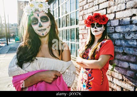 Les femmes sur trottoir portant crâne face paint Banque D'Images