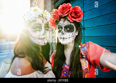 Les femmes sur trottoir portant crâne face paint Banque D'Images