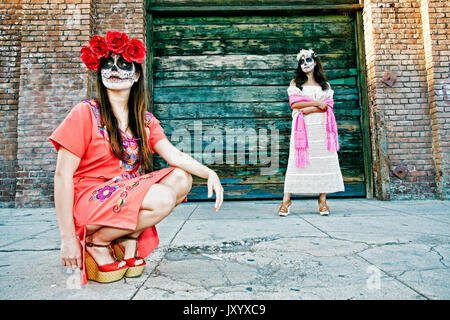 Les femmes sur trottoir portant crâne face paint Banque D'Images