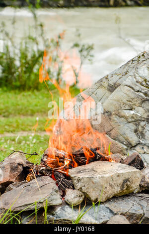 Feu de camp. Le Bonfire dilué dans les rochers dans le contexte de la forêt Banque D'Images