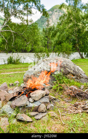 Feu de camp. Le Bonfire dilué dans les rochers dans le contexte de la forêt Banque D'Images