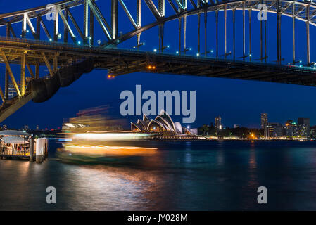 Fiery à Ferry au crépuscule avec le Harbour Bridge et l'Opera House, Sydney, Nouvelle-Galles du Sud, Australie. Banque D'Images