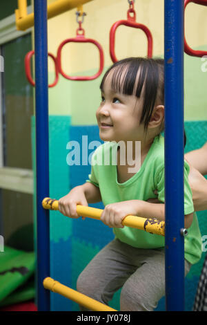 Chinois asiatique little girl hanging on sonne au jeu intérieur Banque D'Images