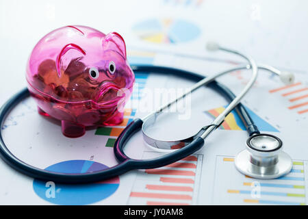 Budget de la santé concept - stethoscope and piggy bank on chartes graphiques Banque D'Images