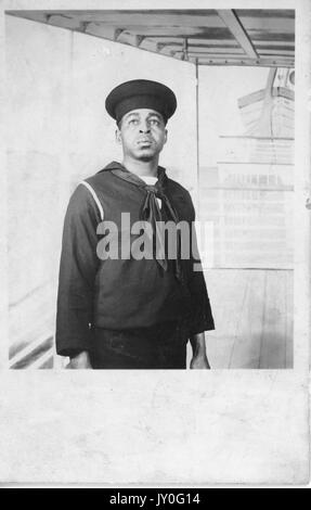 Portrait debout en demi-longueur de jeune Afro-américain d'expression neutre, habillé en tenue de marin, 1920. Banque D'Images