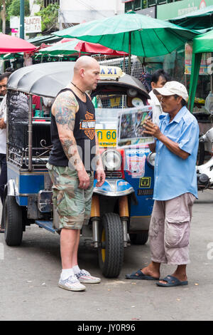 La négociation d'tuk tuk avec chauffeur pour un trajet, Khao San Road, Bangkok, Thaïlande Banque D'Images