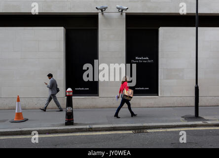 Les Londoniens à pied sous deux caméras CCTV dans la City de Londres, l'un des plus regardé le 11 août, 2017, à Londres, en Angleterre. Selon les chiffres de 2011, il y a 420 000 caméras à Londres. Banque D'Images