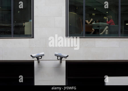 Les Londoniens à pied sous deux caméras CCTV dans la City de Londres, l'un des plus regardé le 11 août, 2017, à Londres, en Angleterre. Selon les chiffres de 2011, il y a 420 000 caméras à Londres. Banque D'Images