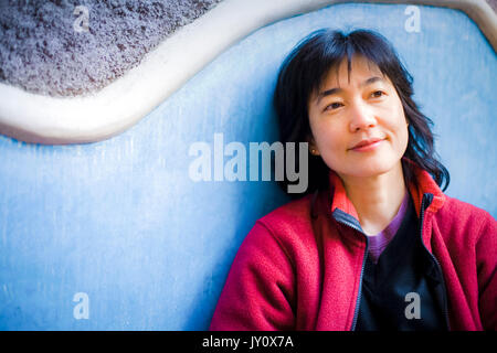 Japonais pensive woman leaning on wall Banque D'Images