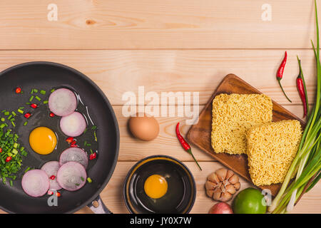 Des nouilles instantanées pour cuisiner et manger dans le plat avec les oeufs et les légumes sur fond de bois. Banque D'Images