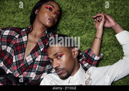 Couple laying on grass holding hands Banque D'Images