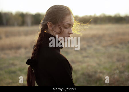 Pensive woman standing in field Banque D'Images