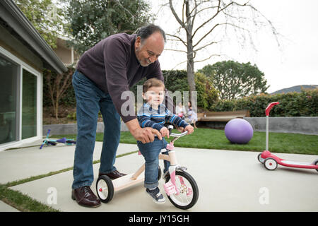 Grand-père petit-fils poussant sur tricycle Banque D'Images