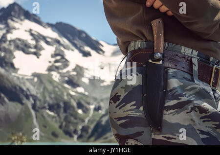 Un soldat vêtu de vêtements de camouflage. Le couteau dans sa gaine sur la courroie à l'infanterie à l'arrière-plan scout de belles montagnes Banque D'Images