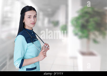 Portrait confiant femme médecin professionnel de santé isolés sur l'hôpital clinique couloir windows background. Expression visage positif Banque D'Images