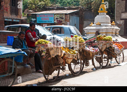 Katmandou, Népal - 9 mars 2013 : les vendeurs de fruits avec location en attente de client par la route de Katmandu. Banque D'Images