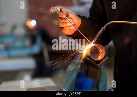 La soudure, avec un chalumeau deux tuyaux métalliques sont soudées, atelier de formation pour les artisans en plomberie et chauffage, Banque D'Images