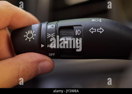 Tourner l'interrupteur d'éclairage de voiture gérer de près. Voiture de commutation main light Banque D'Images
