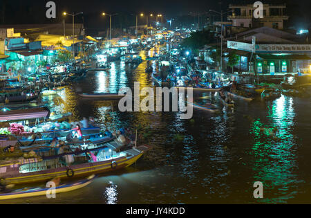 L'aube le marché flottant avec les lumières de nuit occupée bateaux transportant des marchandises au commerce agricole en préparation de Nouvel An lunaire dans Soc Tran Banque D'Images