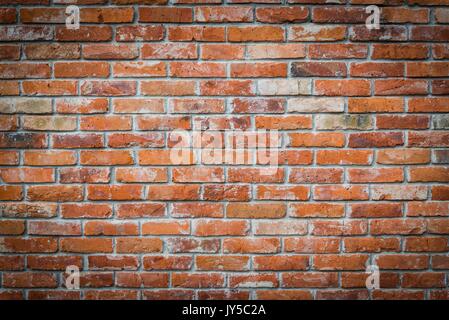 La texture du mur de brique rouge grunge background avec vignetted corners Banque D'Images