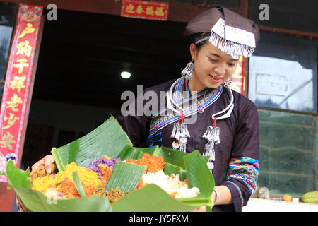 Qiubei, la province chinoise du Yunnan. Août 17, 2017. Un villageois sert de riz coloré en Yile village de Qiubei County, Zhuang et miao de Wenshan Préfecture autonome, le sud-ouest de la province chinoise du Yunnan, le 17 août, 2017. Comme la période de maturité de paddy tombe, les gens commencent à prendre la couleur du riz avec du jus de plantes sauvages comestibles. Dans le comté de Qiubei, le coloré le riz est un aliment populaire parmi les résidents locaux qui croient les couleurs symbolisent la récolte et la bonne fortune. Credit : Jing Huihui/Xinhua/Alamy Live News Banque D'Images