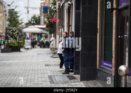 Turku, Finlande. 18 août 2017. La région à la police garde Yliopistonkatu dans le centre de Turku. Deux personnes ont été tués et six autres blessés dans une attaque au couteau place du marché de Turku et Puutori. La police a réussi à arrêter l'attaquant en quelques minutes après le premier appel d'urgence en tirant sur lui à la cuisse. Credit : Jarmo Piironen/Alamy Live News Banque D'Images