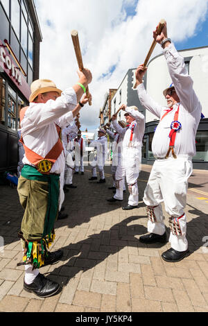 Anglais traditionnel Morris men de Hartley Morris Dancers à l'extérieur de la ville à la rue la semaine annuelle de Broadstairs Folk. La danse de deux lignes portant un pantalon blanc et tee-shirts avec des chapeaux de paille, holding de poteaux. Banque D'Images