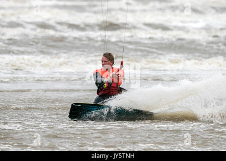 Southport, Merseyside, 19 août 2017. Météo britannique. Vraiment un jour venteux et beaucoup plus frais avec quelques averses éparses n'a pas dissuader ce kite boarder de riding le surf sur la marée de Southport Merseyside. Credit : Cernan Elias/Alamy Live News Banque D'Images