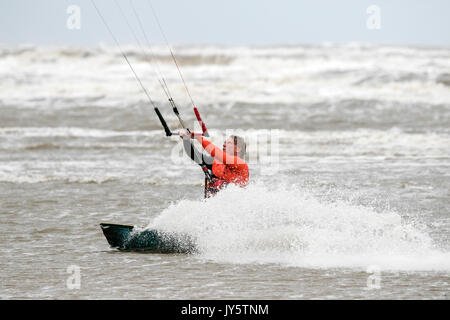 Southport, Merseyside, 19 août 2017. Météo britannique. Vraiment un jour venteux et beaucoup plus frais avec quelques averses éparses n'a pas dissuader ce kite boarder de riding le surf sur la marée de Southport Merseyside. Credit : Cernan Elias/Alamy Live News Banque D'Images