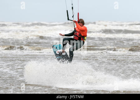 Southport, Merseyside, 19 août 2017. Météo britannique. Vraiment un jour venteux et beaucoup plus frais avec quelques averses éparses n'a pas dissuader ce kite boarder de riding le surf sur la marée de Southport Merseyside. Credit : Cernan Elias/Alamy Live News Banque D'Images