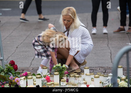 Turku, Finlande. 19 août 2017. Les gens plaçant bougies et fleurs sur le lieu d'agression au couteau dans la place du marché de Turku. Deux personnes ont été tués et six autres blessés dans une agression au couteau qui a eu lieu le vendredi 18 août à la place du marché de Turku et Puutori. La police a réussi à arrêter l'attaquant en quelques minutes après le premier appel d'urgence en tirant sur lui à la cuisse. Enquête sur l'attaque de la police comme un acte de terrorisme. Credit : Jarmo Piironen/Alamy Live News Banque D'Images